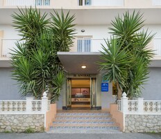 Entrada de hotel con un letrero que dice "H. ANIBAL" y otro que indica "HOSTAL ANIBAL". Hay escalones que conducen a la entrada, y el edificio tiene fachada de piedra con baldosas decorativas.