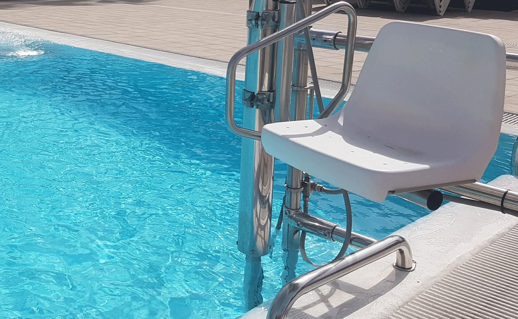Een zwembad met helderblauw water, een witte ligstoel en een metalen zwemladder.