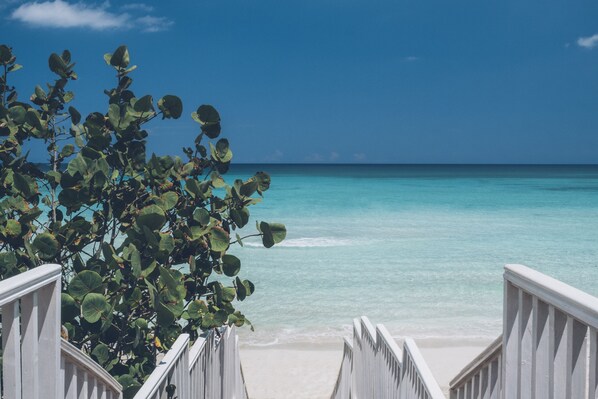 Am Strand, weißer Sandstrand, Liegestühle, Sonnenschirme