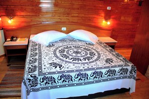 A room with a bed, a bedside table, a telephone, and a wall-mounted light switch. - Mindel Hotel (São Vicente)