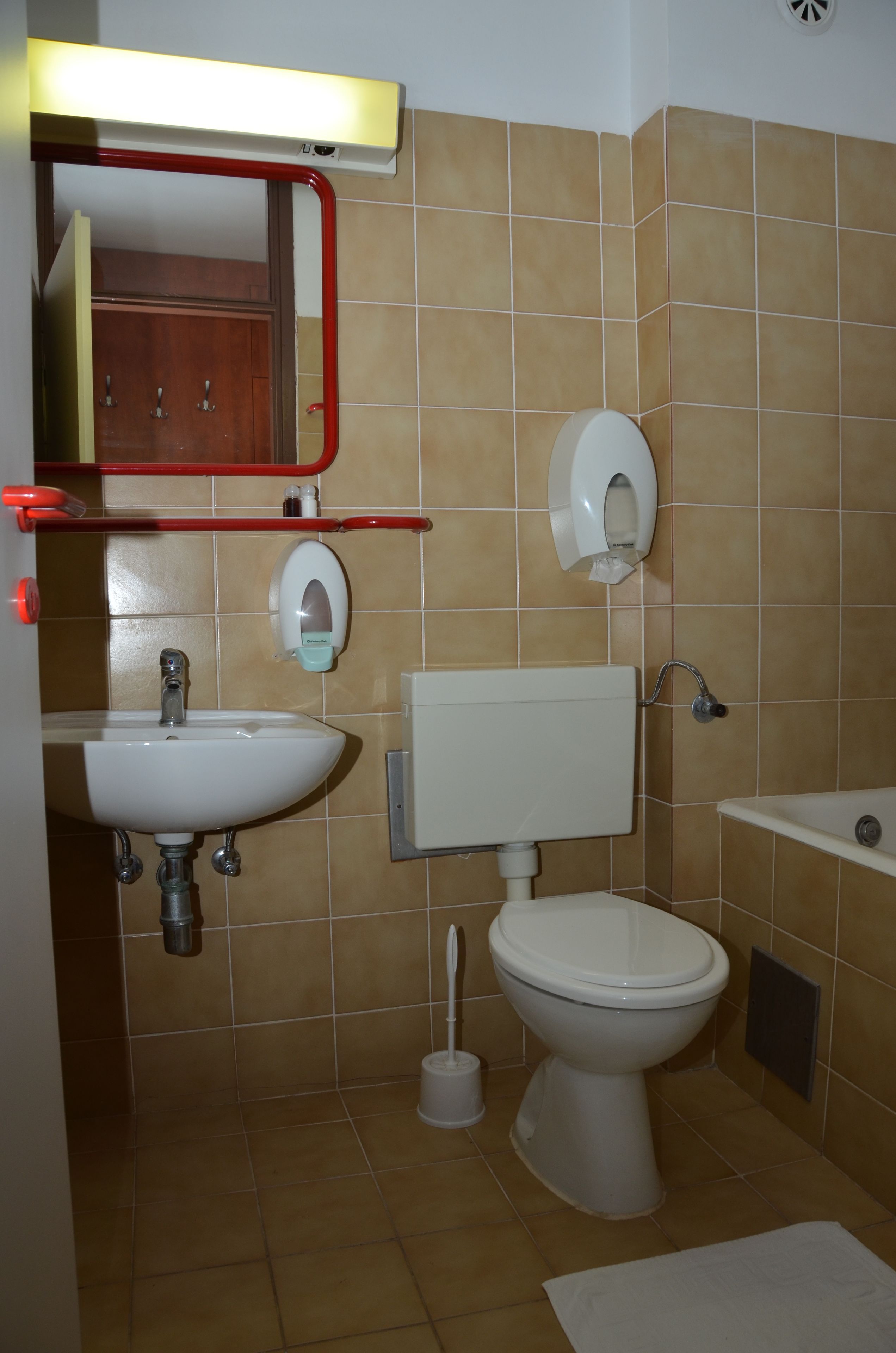 A bathroom with a sink, toilet, and mirror.