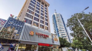Un hôtel doté d’une façade moderne, de grandes fenêtres et d’une enseigne bien visible avec des caractères chinois.