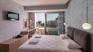 A modern hotel room with a large bed, a desk, and a TV. - Kathrin Beach Hotel (ADELIANOS KAMPOS)