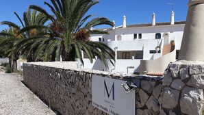 Mural de pedra com placa indicando estacionamento privado para o Hotel Vilamar.