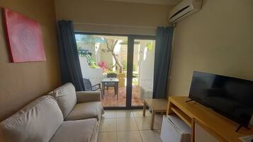 Habitación estándar, balcón | Área de sala de estar | Televisión de 80 cm con canales digitales