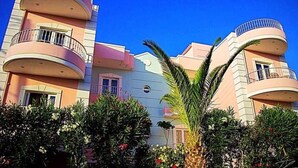 Un edificio de varios pisos con balcones y un cielo azul despejado.