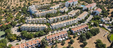 Vista aérea de una zona residencial con varios edificios de apartamentos, calles y áreas verdes.