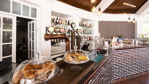 A bar area with a brick wall, wooden ceiling, and exposed pipes. - Quinta do Morgado - Monte da Eira (Tavira)