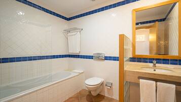 Une salle de bain équipée d’une baignoire, de toilettes, d’un lavabo et d’un miroir.