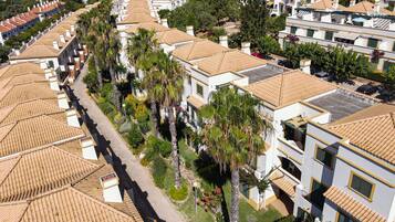 Un quartier résidentiel composé de plusieurs immeubles à deux étages, chacun étant doté d’un toit en tuiles et de balcons.