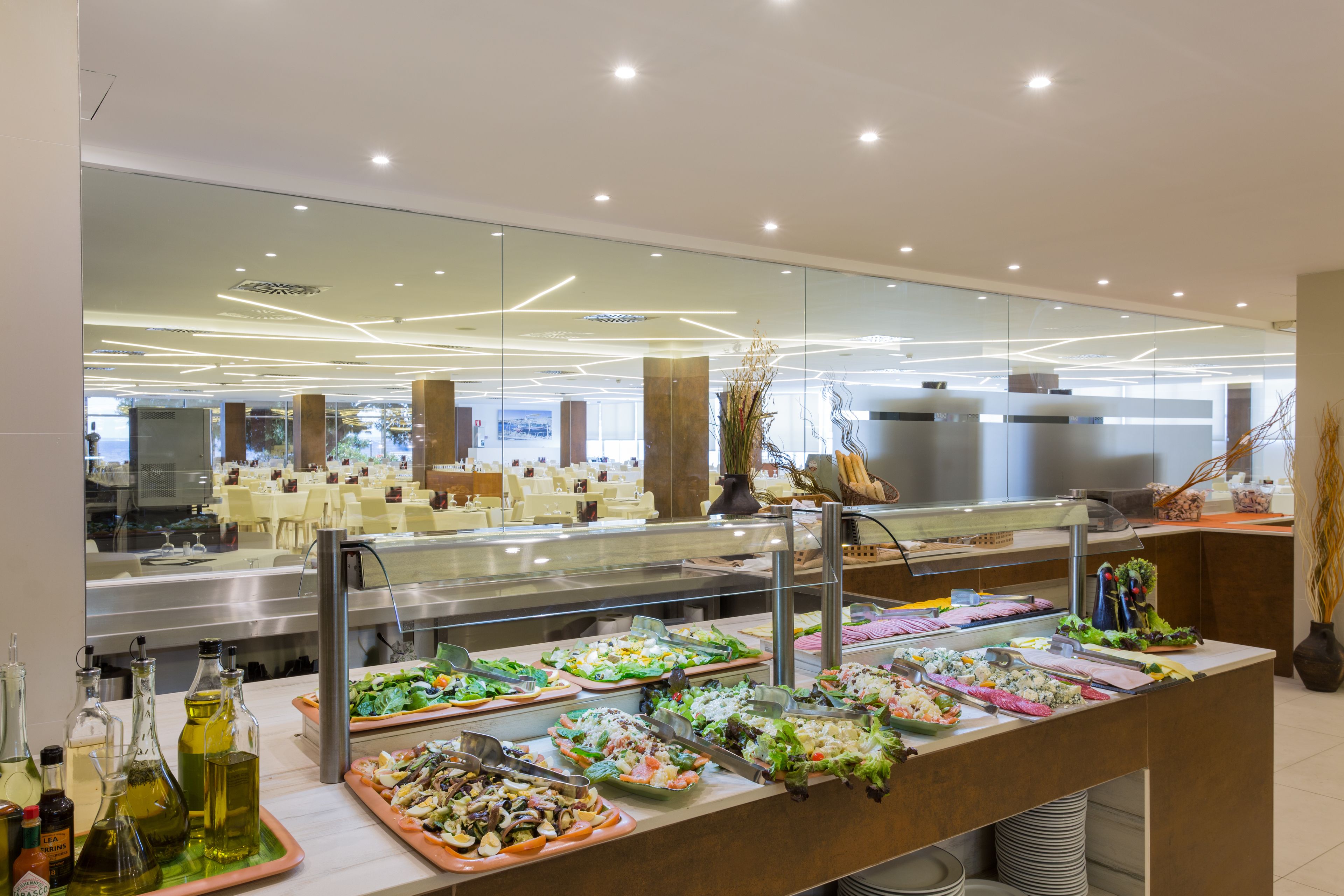 Un bufé con diversas opciones de comida y un diseño de interiores moderno.