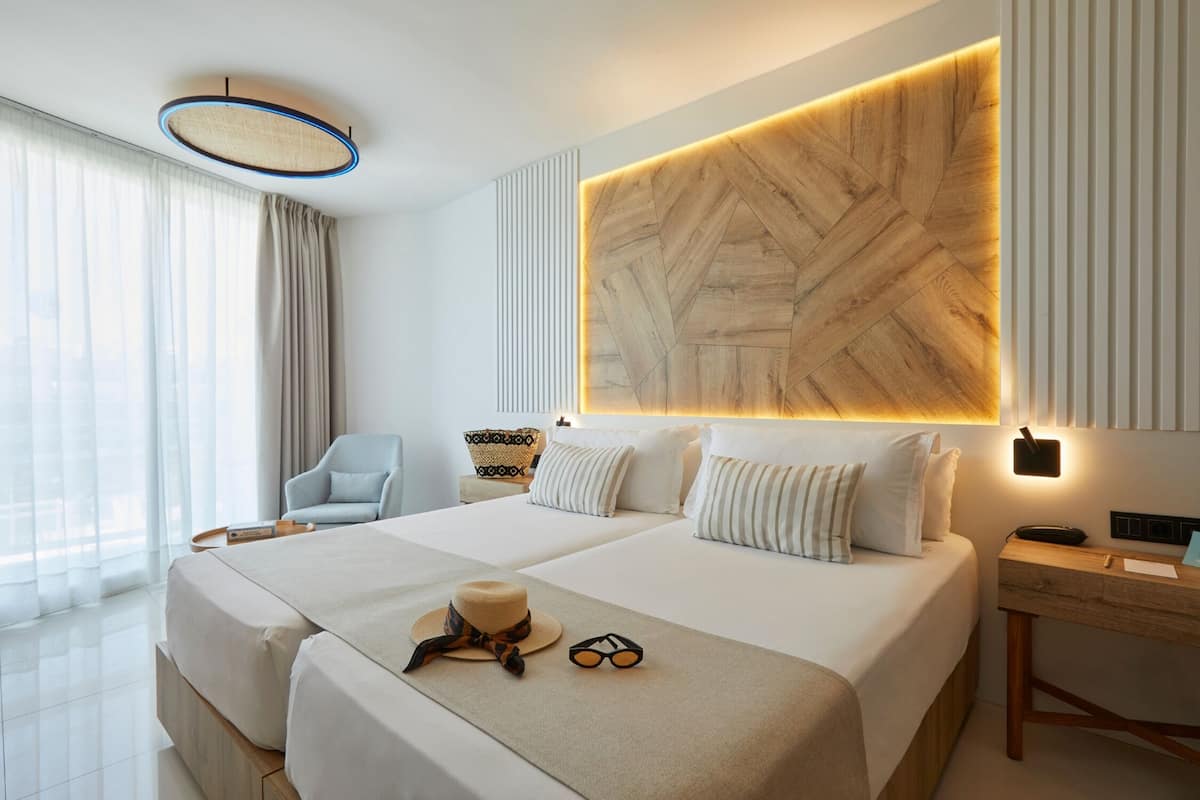 Une chambre d’hôtel moderne, dotée d’un grand lit, d’un bureau et d’une chaise.