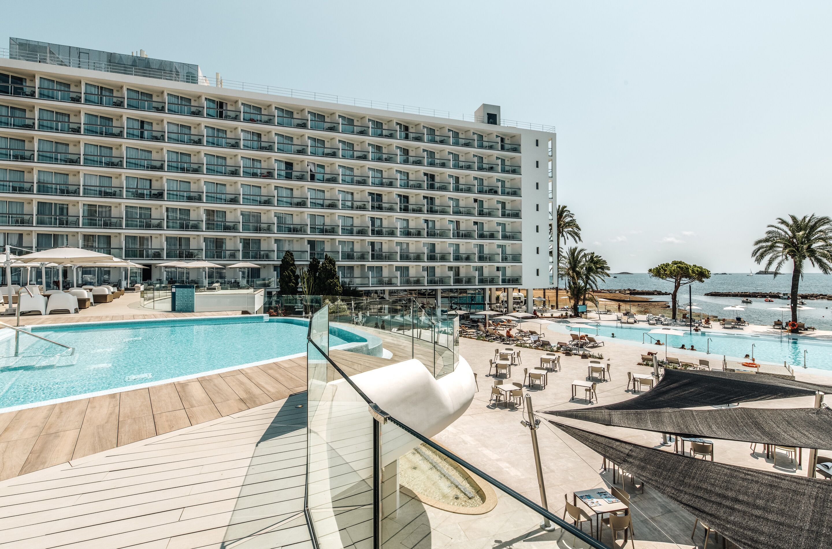 Un hôtel doté d’une grande piscine, d’un espace extérieur aménagé et offrant une vue sur la mer.