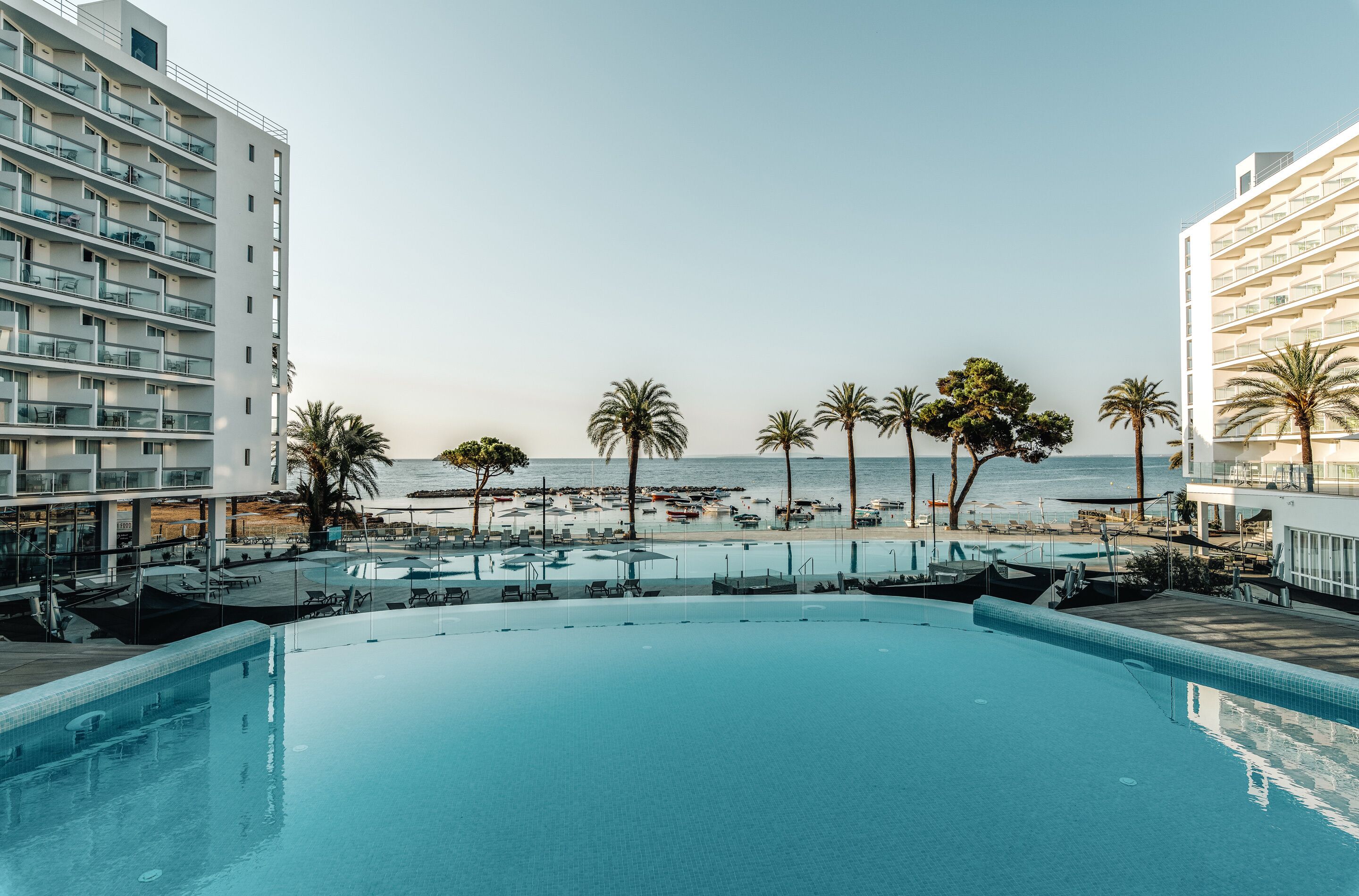 A hotel pool with a view of the beach and ocean.