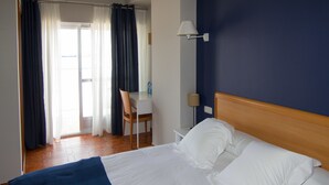 Een hotelkamer met een bed, een bureau en een stoel.