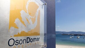 Een bord voor Hotel OsonDomar Playa met uitzicht op de kust.