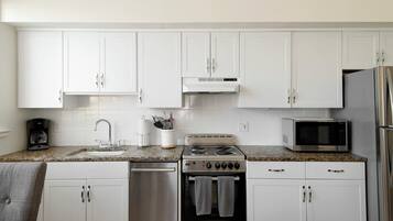 Suite, 2 Bedrooms | Private kitchen | Full-sized fridge, microwave, stovetop, dishwasher