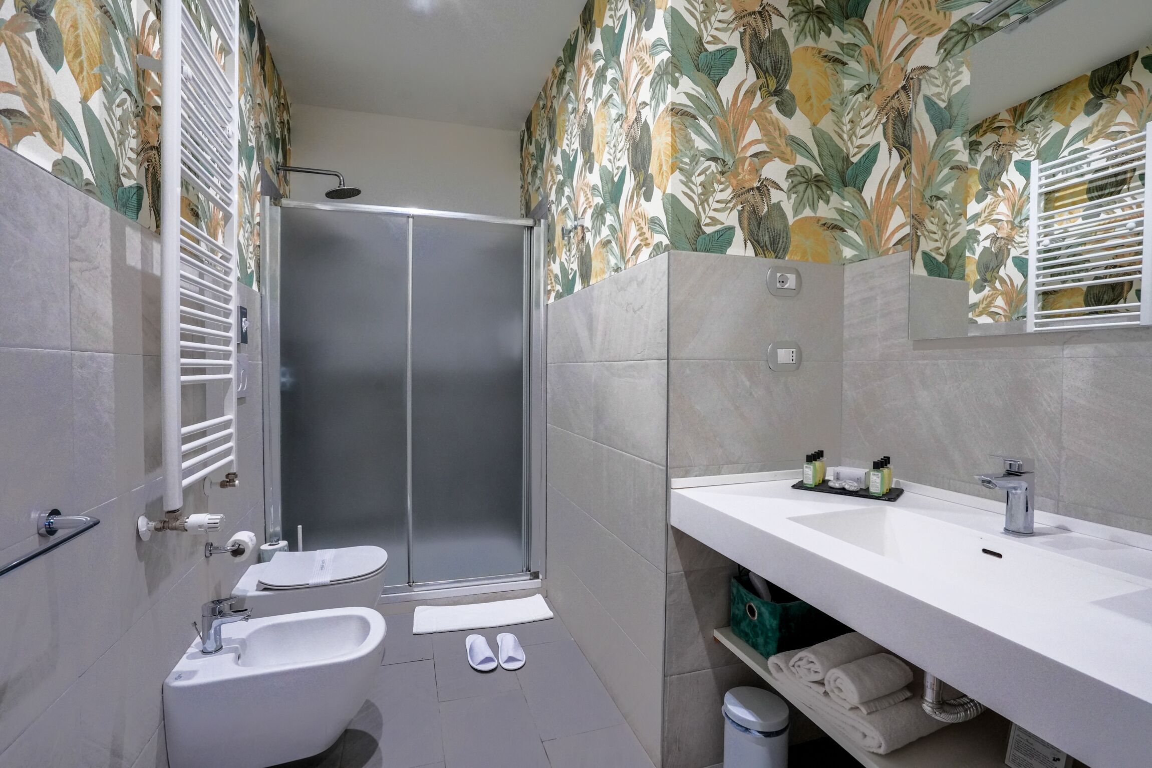 Une salle de bain moderne équipée d’une douche, d’un bidet et d’un lavabo.