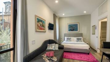 Un dormitorio moderno con cama, sofá y vista a un edificio.