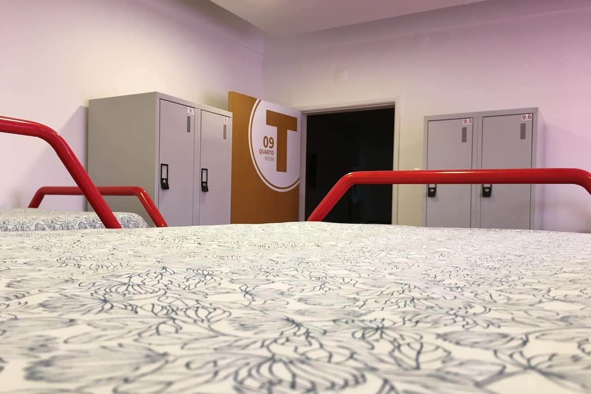 A hotel room with a bed, a wardrobe, and a door to a bathroom.
