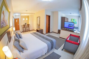 Contemporary hotel room with a large bed, desk area, and seating space.