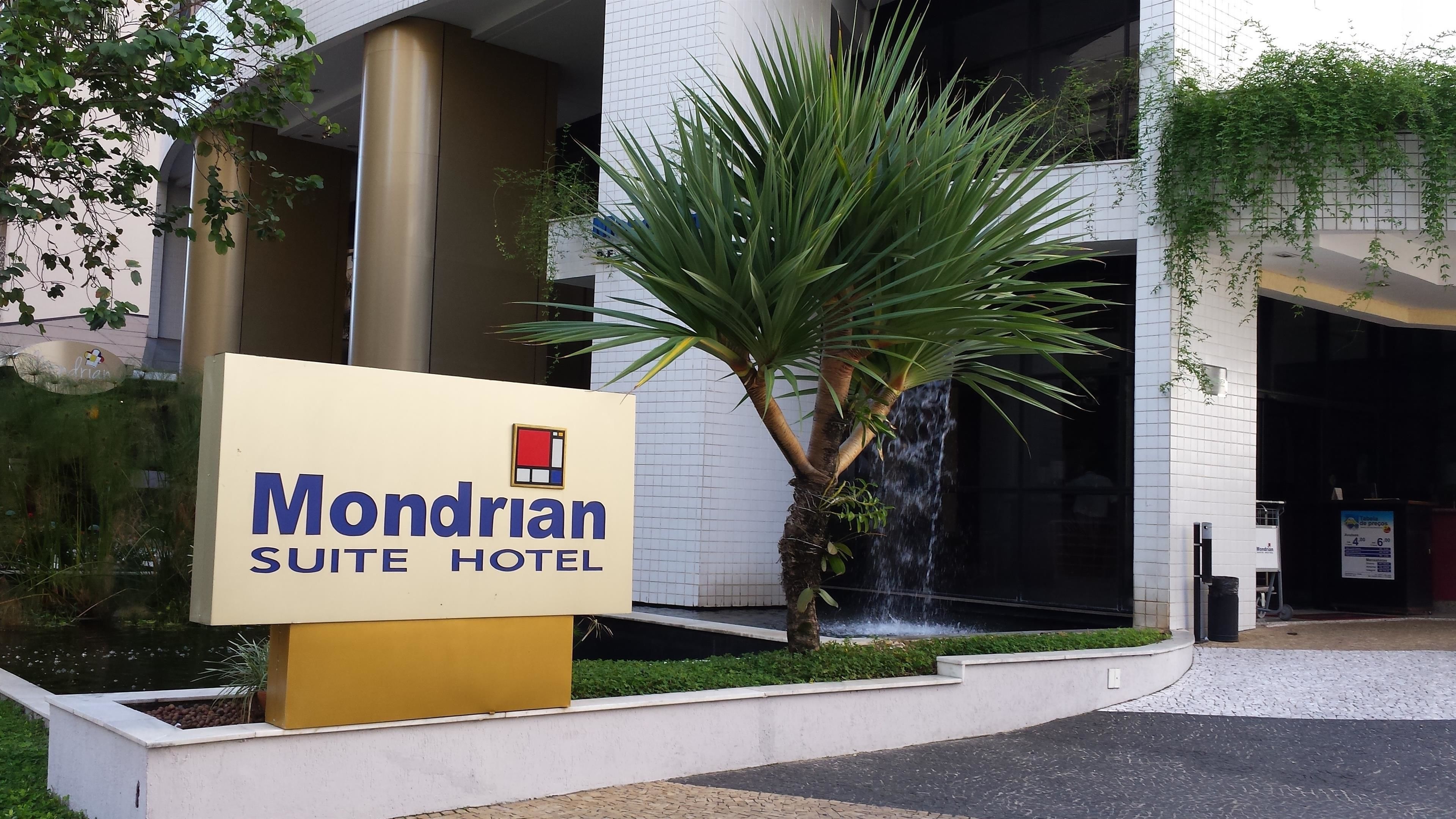 Señal del Mondrian Suite Hotel, con un elemento acuático y una palmera al frente.