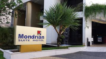 Señal del Mondrian Suite Hotel, con un elemento acuático y una palmera al frente.