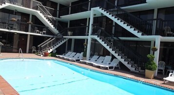 Una piscina al aire libre de temporada, sillones reclinables de piscina