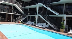 Una piscina al aire libre de temporada, tumbonas