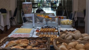 A buffet with various food items including pastries, fruits, and beverages. - Hotel Royal Colonia (Colonia del Sacramento)