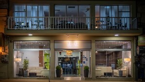 A hotel with a balcony, a sign reading "ROYAL HOTEL", and a storefront with furniture displayed outside. - Hotel Royal Colonia (Colonia del Sacramento)