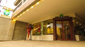 The exterior of the Cebu Hotel with a signboard, entrance, and two flower arrangements. - Cebu R Hotel Mabolo (Cebu City)