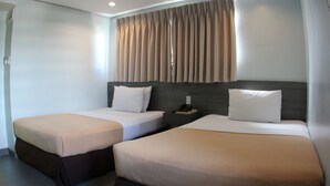 A hotel room with two single beds, a nightstand, and a window with curtains. - Cebu R Hotel Mabolo (Cebu City)