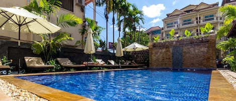 Piscine extérieure, parasols de plage, chaises longues