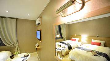 A hotel room with two beds, a desk with a chair, a small table with a plant, a mirror, and a television on the wall.