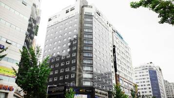 Un hotel de varios pisos con un diseño moderno, que cuenta con un llamativo letrero 'Grayson' en la fachada.