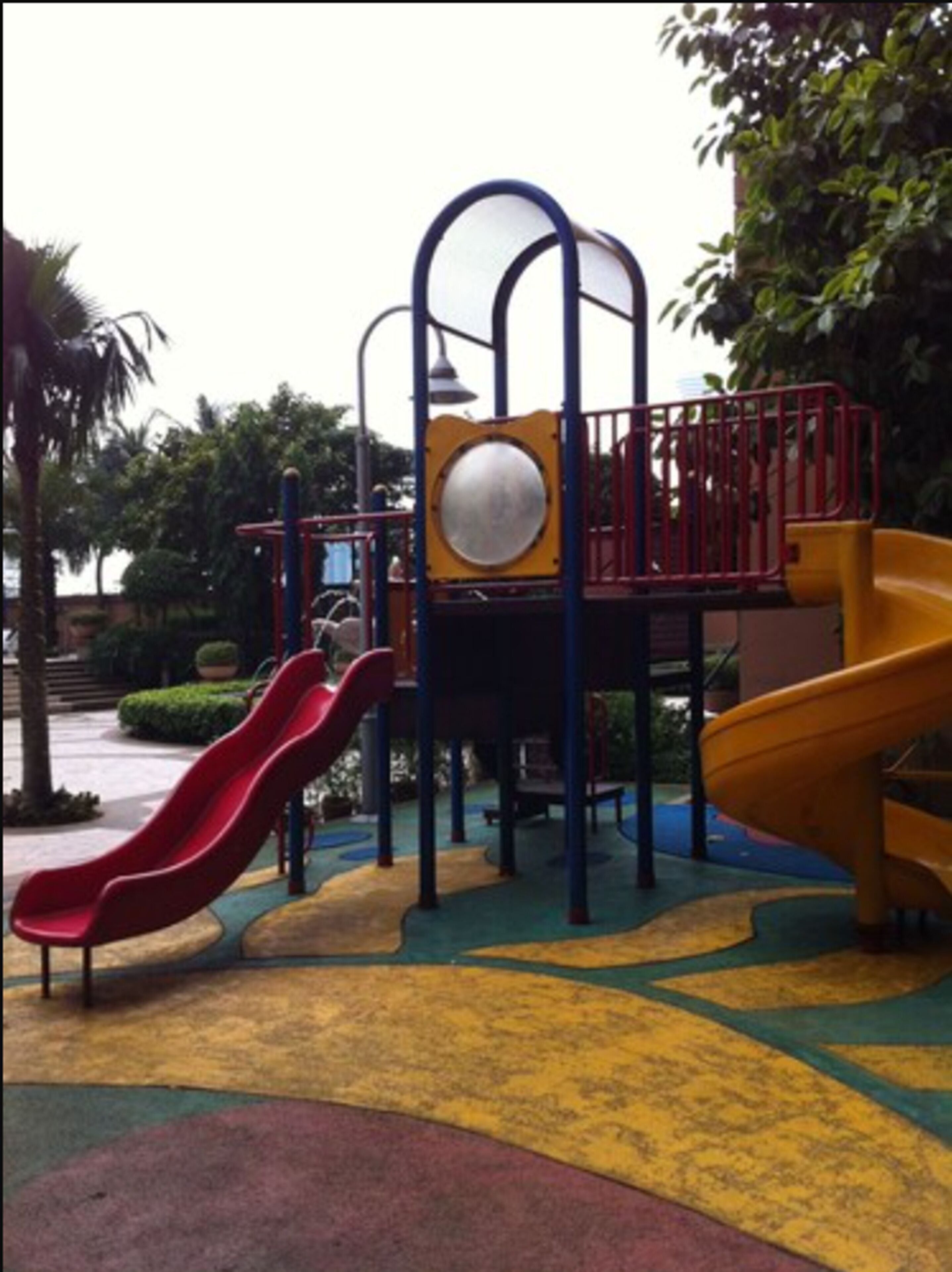 A playground with two slides and a climbing structure.