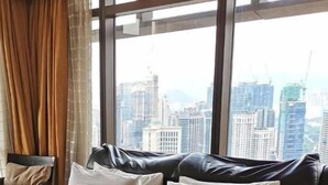 Ein Zimmer mit großem Fenster und Blick auf eine Skyline mit hohen Gebäuden.