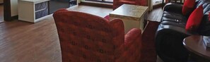 A room with a red patterned armchair, a black leather sofa, and a small table. - Times Private Serviced Suites (Kuala Lumpur)