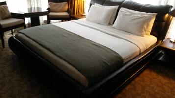 Une chambre d’hôtel avec un grand lit, un bureau, une chaise et une lampe.