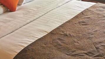 Una cama con una colcha y almohadas estampadas.