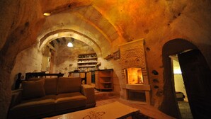 Un interior acogedor con un arco de piedra, un sofá, una chimenea y una zona de bar.