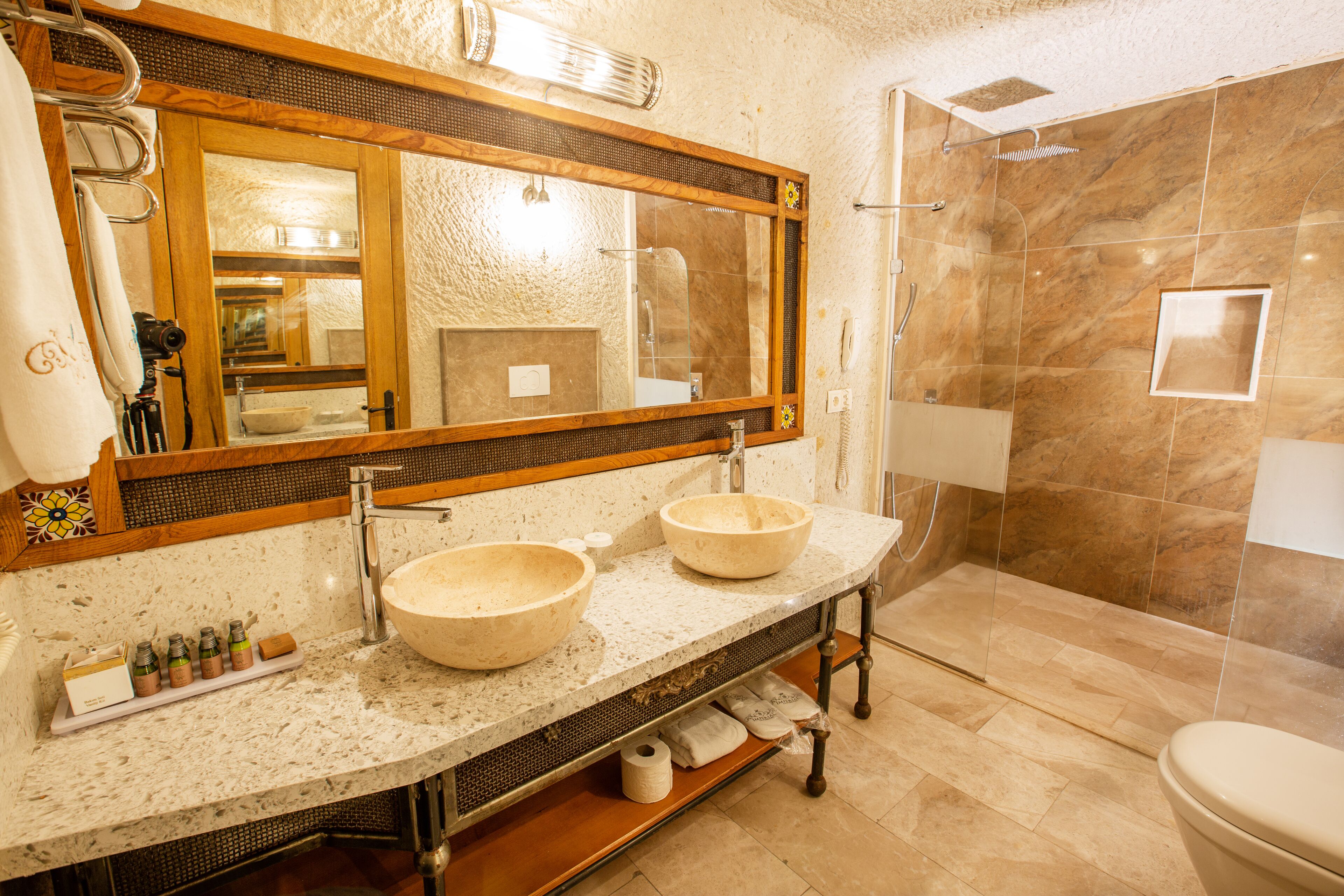 A bathroom with two sinks, a large mirror, and a shower area.