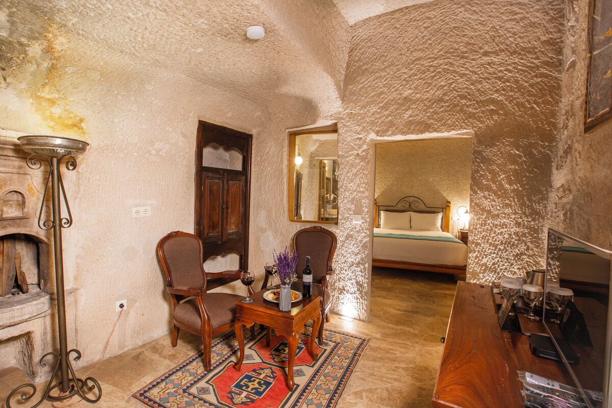 A rustic room with a fireplace, wooden furniture, a bed, and a mirror.