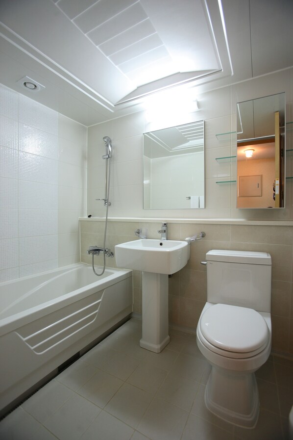 A modern bathroom with a bathtub, sink, and toilet.