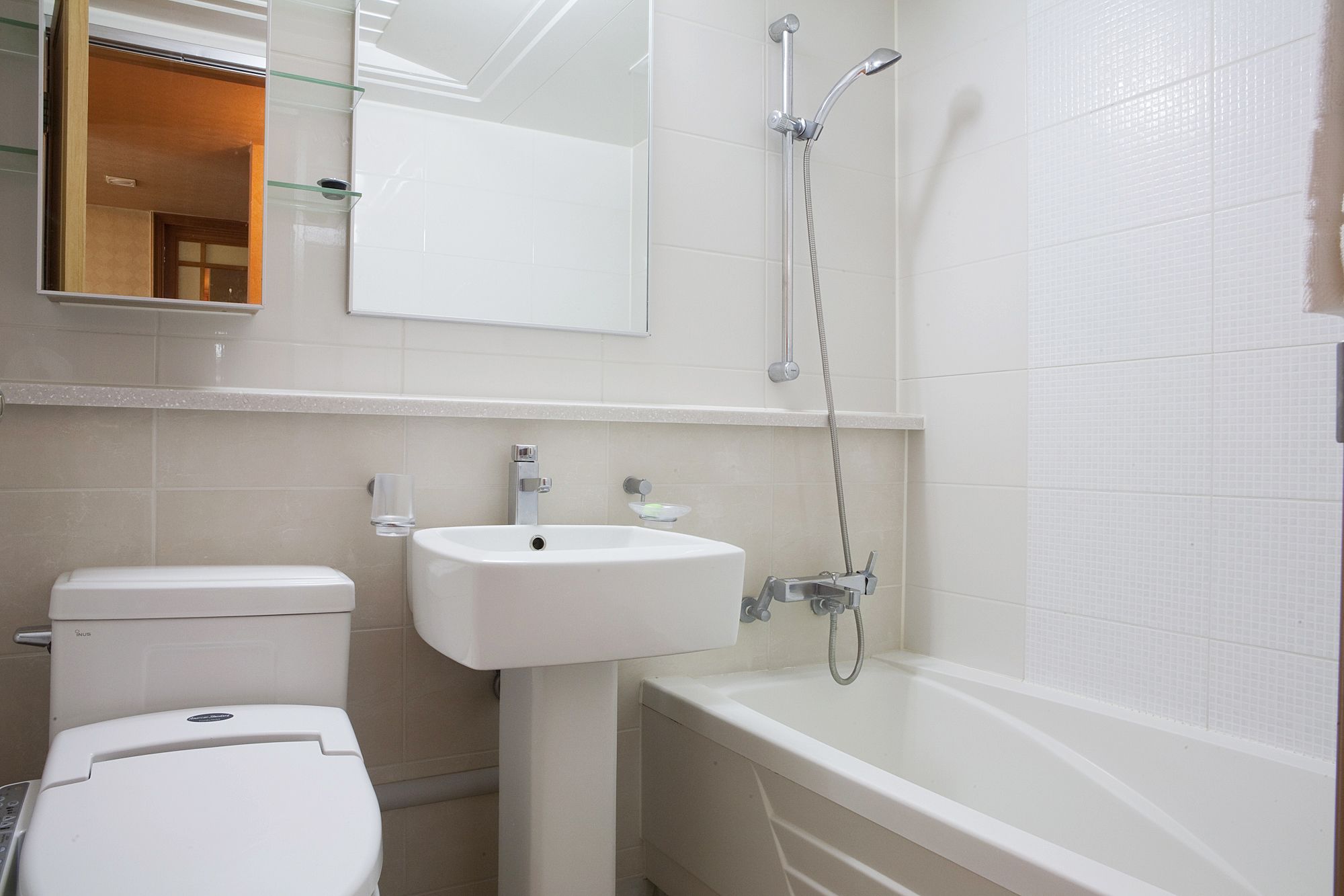 A bathroom with a toilet, sink, and bathtub.