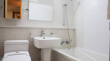A bathroom with a toilet, sink, and bathtub.