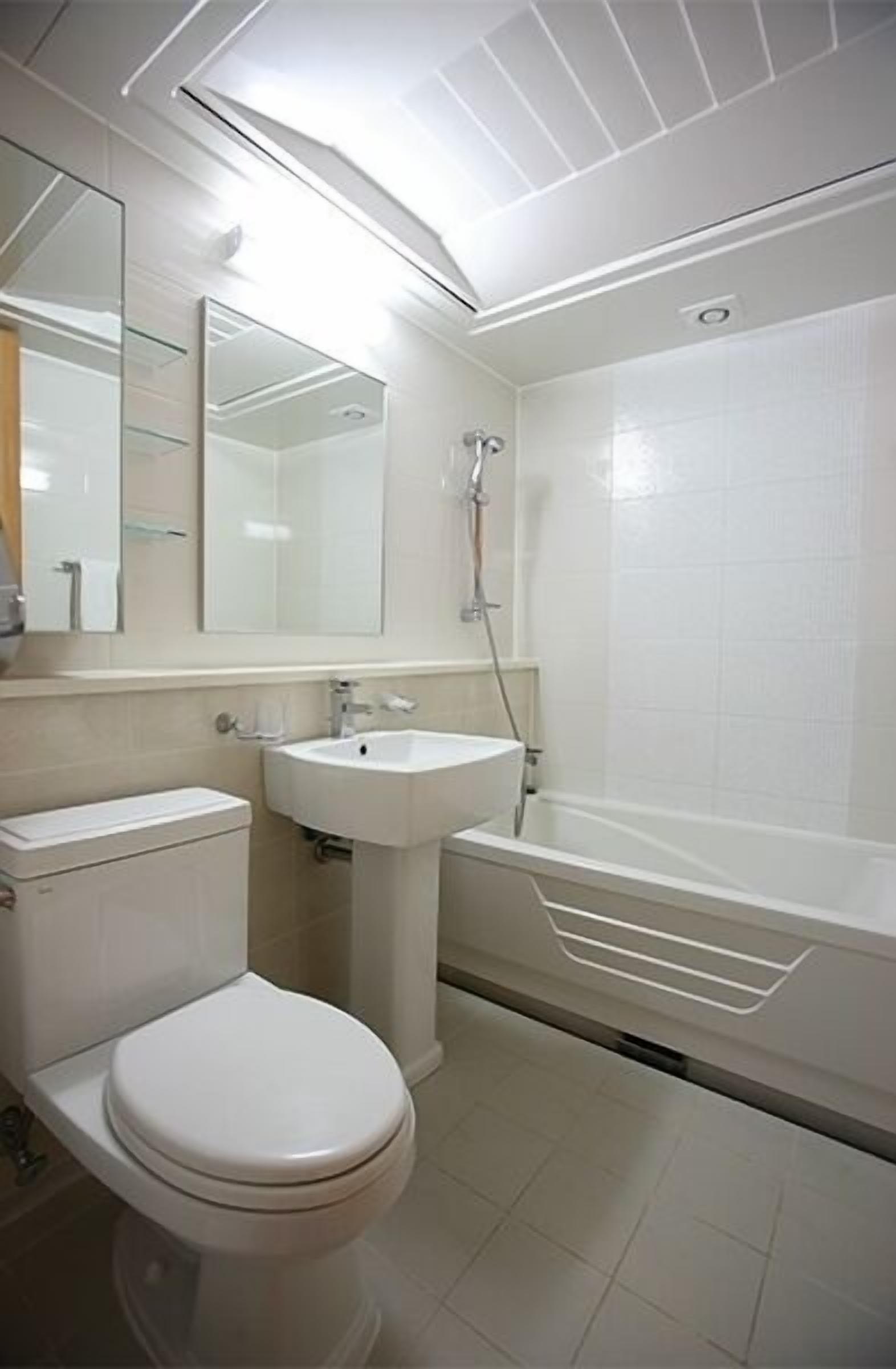 Un baño con inodoro, lavamanos y bañera.