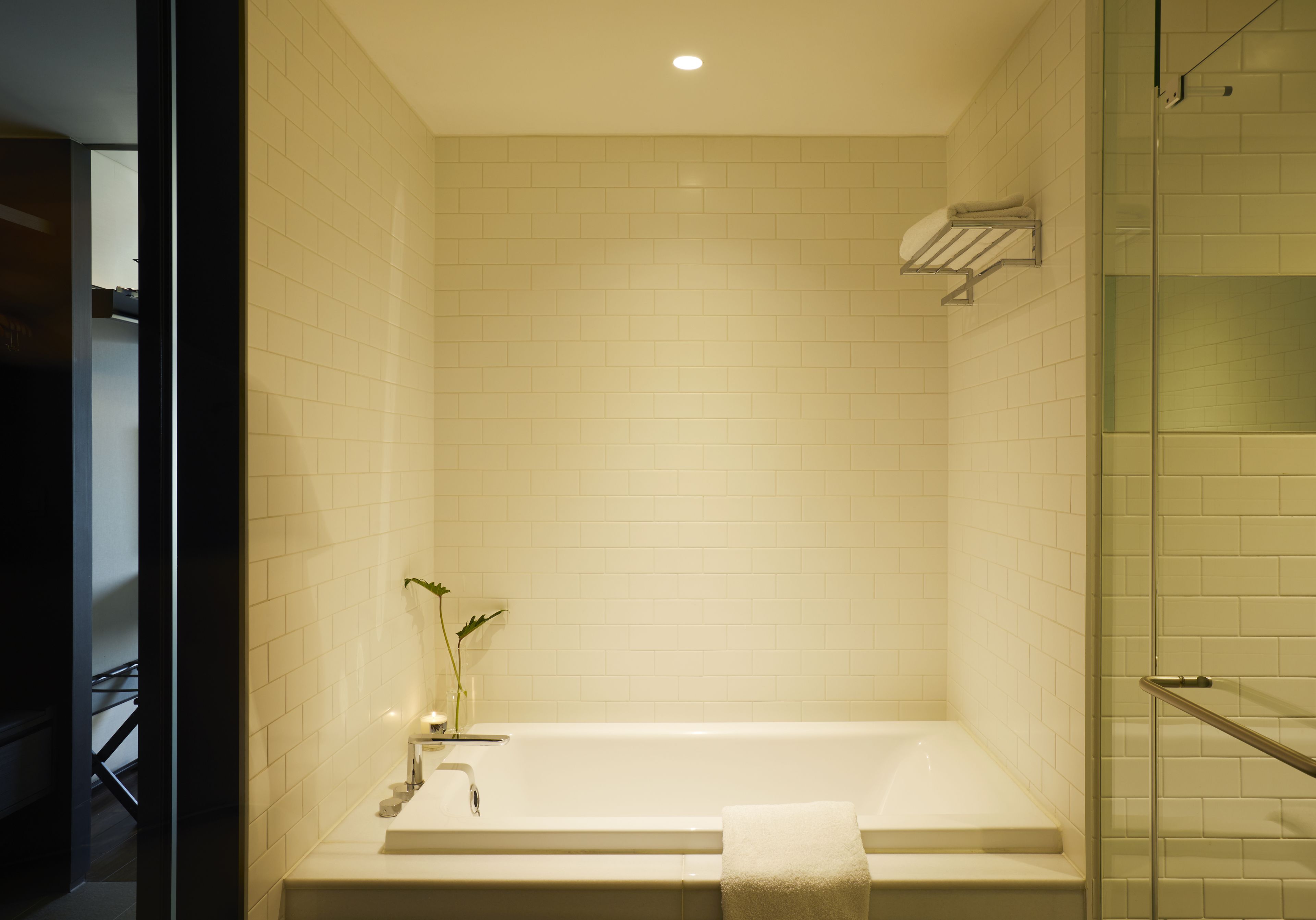 Une salle de bain moderne avec une baignoire sur pieds, une cabine de douche en verre et un porte-serviettes.