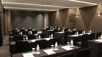 A conference room with multiple tables, chairs, water bottles, and nameplates.